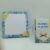 Gros plan sur un bloc-notes A6 quadrillé avec décor floral citron et un marque-page magnétique islamique posé à la verticale.