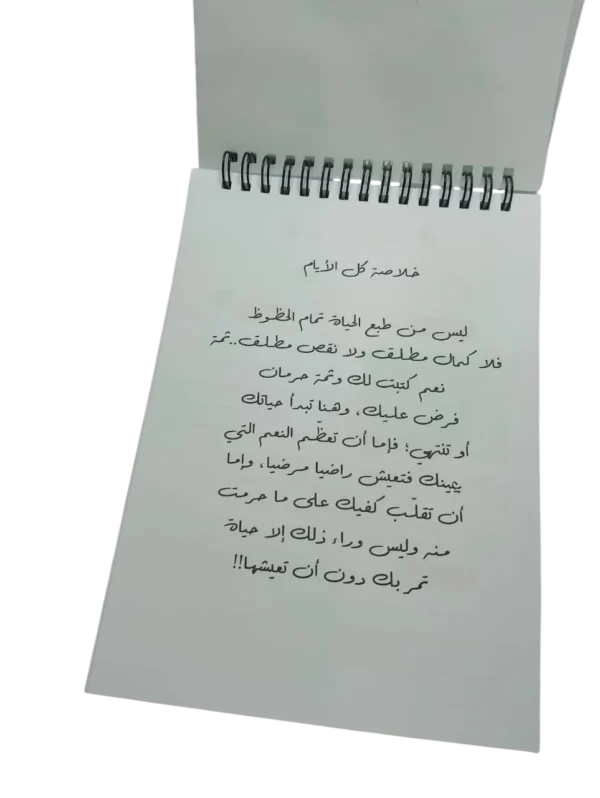 Page intérieure du carnet affichant un poème ou une citation de motivation en calligraphie arabe sur le contentement et le destin.